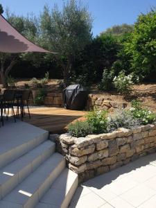a patio with a stone wall and a table and chairs at Villa Lumie - Superbe villa pour 8 personnes entièrement rénovée en 2023 avec piscine privée in Sainte-Maxime