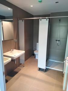 een badkamer met een douche, een wastafel en een toilet bij Albergue de Cerceda in Cerceda