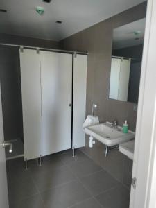 een badkamer met een wastafel, een toilet en een spiegel bij Albergue de Cerceda in Cerceda