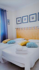 two white beds with pillows on them in a room at Oasis Lighthouse in Portimão