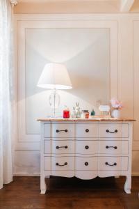 a white dresser with a lamp on top of it at Ginevra Suite in Cortona