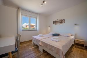 a bedroom with a bed with two towels on it at Villa Ema and Ana in Pula