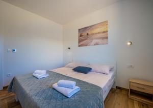 ein Schlafzimmer mit einem Bett mit zwei Handtüchern darauf in der Unterkunft Villa Ema and Ana in Pula