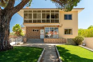 a house with a tree in front of it at Lisbon Surf Hostel in Carcavelos