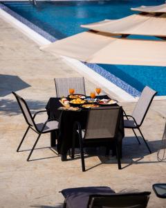a table with food and drinks on it next to a pool at Sunny Garden in Ulcinj