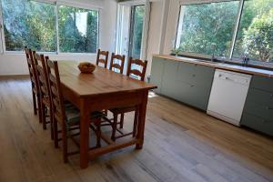 a kitchen with a wooden table and chairs and windows at L Oustal maison vigneronne in Villeneuve-lès-Béziers +13 photos