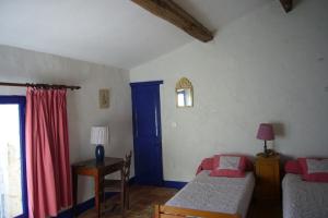 a bedroom with two beds and a blue door at L Oustal maison vigneronne in Villeneuve-lès-Béziers