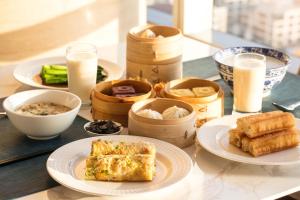 a table with plates of food and bowls of food at The Westin Nanjing Xuanwu Lake in Nanjing