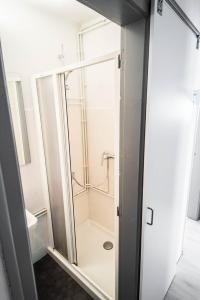 een badkamer met een douche en een glazen deur bij Beach Lovers' Paradise, bright apartment for 2/3 in Vilanova i la Geltrú