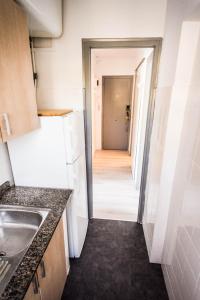 a kitchen with a white refrigerator and a hallway at Beach Lovers' Paradise, bright apartment for 2/3 in Vilanova i la Geltrú