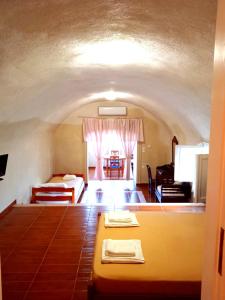a living room with a bed and a room with a couch at Loukas Kontos Traditional House in Emporio Santorini