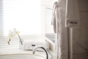 a white bathroom with a sink and a window at The Westin Nanjing Xuanwu Lake in Nanjing