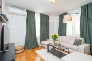 a living room with a white couch and a tv at Villa MarLea in Dubrovnik