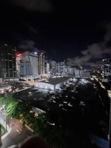 uma cidade à noite com carros estacionados num parque de estacionamento em Live the BGC lifestyle! em Manila