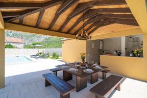 eine Terrasse mit einem Tisch und Bänken sowie eine Küche in der Unterkunft Villa MarLea in Dubrovnik