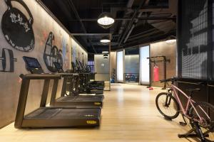 a gym with a row of exercise bikes on a treadmill at Moxy Xi'an Downtown in Xi'an