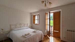 a bedroom with a bed with two towels on it at Casas El Jogueru in Ribadesella