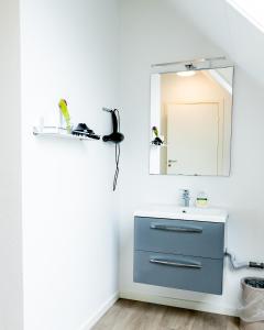 ein Badezimmer mit einem blauen Waschbecken und einem Spiegel in der Unterkunft Abild Kro & Hotel in Tønder