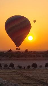 a hot air balloon flying in front of the sunset at Nile diana luxor in Luxor