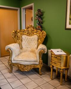 a gold chair in a room with a table at Abild Kro & Hotel in Tønder