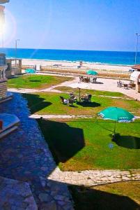 um parque com uma praia e um guarda-sol e o oceano em قريه جرين لاند العريش em El Arish