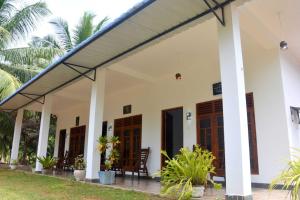 a house with awnings and a porch at Wilpattu Lakwin Guest in Pahala Maragahawewa