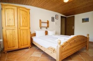 ein Schlafzimmer mit einem großen Holzbett in einem Zimmer in der Unterkunft zentral aber ruhig, Terrasse mit viel Grün - strandnahes Ferienhaus Luki in Göhren