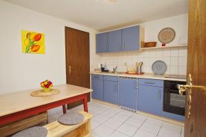 a kitchen with blue cabinets and a counter top at zentral aber ruhig, Terrasse mit viel Grün - strandnahes Ferienhaus Luki in Göhren