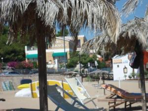 a group of chairs and umbrellas on a beach at Hotel Vela Velo Club Vieste in Vieste