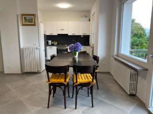 una cucina con tavolo e sedie con un vaso di fiori di Rosa dei Venti a Baveno Altre 10 foto