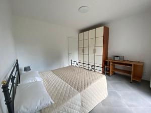 1 dormitorio con cama, tocador y mesa en Rosa dei Venti, en Baveno