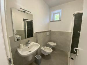 un bagno bianco con lavandino e WC di Rosa dei Venti a Baveno