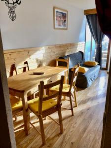 a wooden table and chairs in a living room at V du Bachat Arolles A12 - Appt 6 pers in Chamrousse