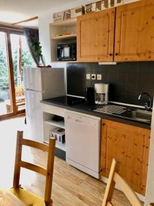 a kitchen with wooden cabinets and a white refrigerator at V du Bachat Arolles A12 - Appt 6 pers in Chamrousse