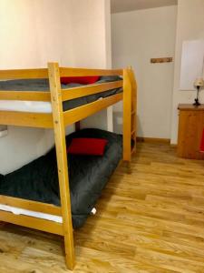 two bunk beds in a room with a wooden floor at V du Bachat Arolles A12 - Appt 6 pers in Chamrousse