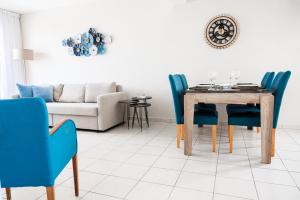 uma sala de jantar com uma mesa e cadeiras azuis em Narcissos 'Nissi Beach' Apartment E9 em Agia Napa