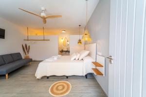 a bedroom with a bed with pillows and a couch at Calas De Meca in Los Caños de Meca