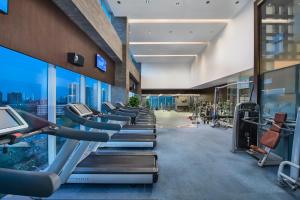 a gym with a row of treadmills and machines at Crowne Plaza Beijing Sun Palace by IHG in Beijing