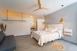a bedroom with a white bed and a couch at Calas De Meca in Los Caños de Meca