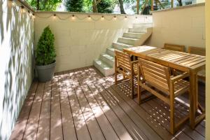 a patio with a wooden table and chairs on a deck at Apart Hotel Zborovska in Prague