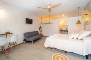 a bedroom with two beds and a chair at Calas De Meca in Los Caños de Meca
