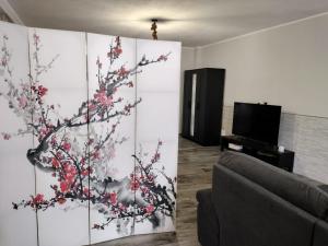 una sala de estar con una pared con una pintura de un árbol en La casa di Ali, en Torre Maggiore