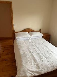 a bed with white sheets and pillows in a bedroom at Modern 4 Bed House in town in Tobercurry