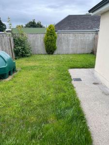 a yard with a fence and a green lawn at Modern 4 Bed House in town in Tobercurry