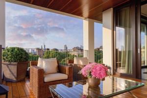 a balcony with wicker chairs and a glass table at Bulgari Hotel Milano in Milan
