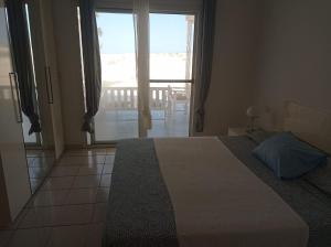 um quarto com uma cama e uma grande janela em Ocean House sol y mar #1 em Rabil
