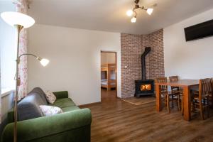 a living room with a couch and a table and a fireplace at VILA Stella in Bystrá