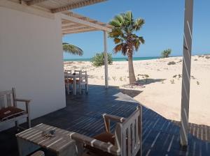 a patio with a table and chairs on the beach at Ocean House sol y mar #1 in Rabil