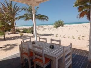 einen Holztisch und Stühle am Strand in der Unterkunft Ocean House sol y mar #1 in Rabil