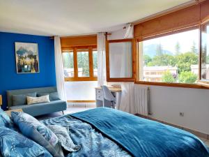 Schlafzimmer mit einem Bett, einem Stuhl und Fenstern in der Unterkunft Villa San Lure Jaca in Jaca